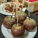 Delicious chocolate-covered apples adorned with colorful sprinkles, perfect for festive occasions.