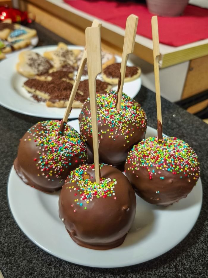 Delicious chocolate-covered apples adorned with colorful sprinkles, perfect for festive occasions.